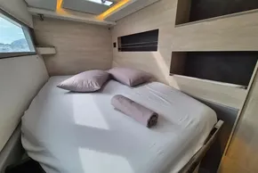 Modern bedroom interior on a 2020 Leopard 45 yacht, featuring a cozy bed and natural light.