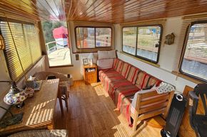 Cozy interior of a 1927 Classic Dutch Barge with wooden decor and striped sofa.