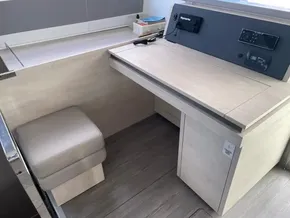 Modern navigation station on 2020 Leopard 50 yacht with control panel and cushioned seat.
