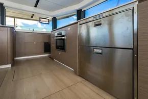 Modern kitchen interior on 2025 Leopard 46 yacht, featuring stainless steel appliances and wood cabinetry.