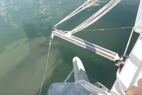 Close-up of a 2017 Lagoon 42 catamaran's anchor and rigging over calm water.
