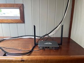Wi-Fi router setup on a wooden surface inside a classic 1901 Dutch barge.