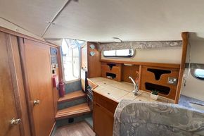 Interior of 1991 Sealine 290 Ambassador boat with wooden cabinetry and compact kitchen area.