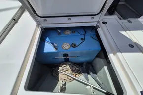 Open storage compartment on 2021 Leopard 45 yacht with blue tank and coiled rope.