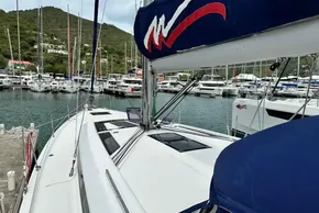 2023 Beneteau Oceanis 51.1 yacht docked in a marina, surrounded by sailboats.