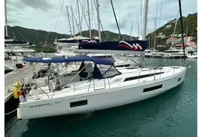 2023 Beneteau Oceanis 51.1 yacht docked in a marina, featuring sleek design and blue canopy.
