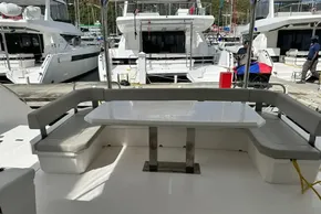 Leopard 46 Powercat 2025 yacht with outdoor seating and table in marina setting.