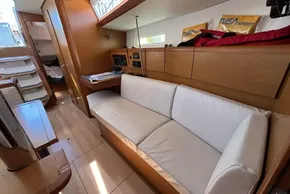 Interior of 2020 Jeanneau Sun Odyssey 389 yacht with white sofa and wooden finishes.