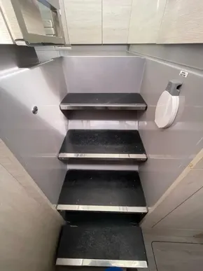 Compact staircase in a 2020 Leopard 50 yacht interior, featuring sleek black steps.