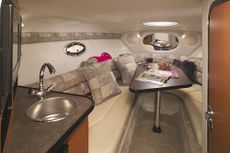 Crownline Cuddy Cabin 275 CCR - Premium carpeting, galley and dining area with portable table that converts to a V-bunk