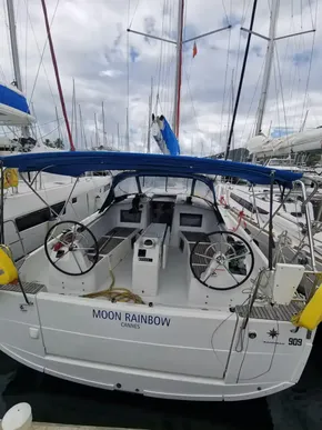 2020 Jeanneau Sun Odyssey 410 sailboat docked, featuring dual steering wheels and a blue canopy.