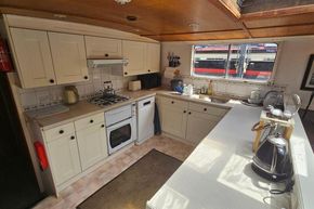 Cozy kitchen interior of a 1926 Dutch Barge Luxemotor, featuring modern appliances and ample counter space.