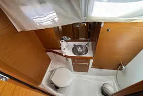 Compact bathroom in 2020 Jeanneau Sun Odyssey 389 yacht, featuring sink, toilet, and storage.