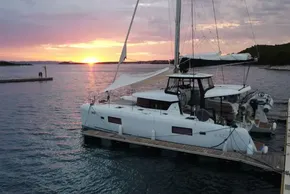 2024 Lagoon 42 catamaran docked at sunset, serene waterscape.