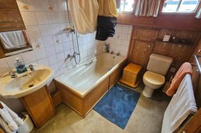 Bathroom interior of a 1926 Dutch Barge Luxemotor with sink, bathtub, and toilet.