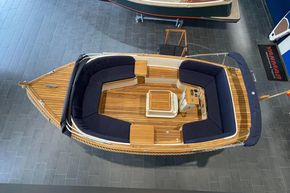2026 Enkhuizensloep 615 boat with wooden deck and navy seating, viewed from above.