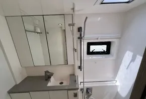 Modern bathroom in 2019 Leopard 45 catamaran with shower, sink, and mirrored cabinets.