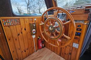 1921 Classic Dutch Barge helm with wooden wheel and nautical controls.