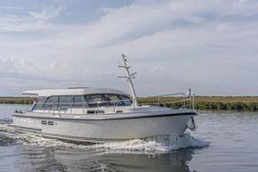 2025 Linssen 45 SL Sedan cruising on a calm river under a clear sky.