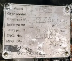 Blurred engine specification plate with model and manufacturing details, including power and speed ratings.