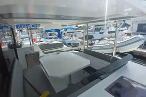 Outdoor seating area on a 2022 Leopard 45 catamaran docked at a marina.