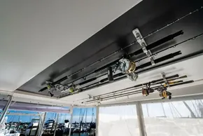Fishing rods stored on a 2022 Leopard 50 yacht, with marina view in background.