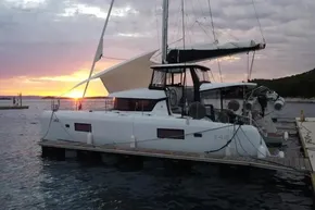 2024 Lagoon 42 catamaran docked at sunset, featuring sleek design and modern sails.