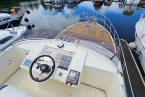 1989 Princess 35 Flybridge yacht with wooden deck, docked in a marina.