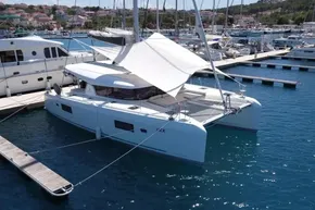 2024 Lagoon 42 catamaran docked at marina, featuring sleek design and spacious deck.
