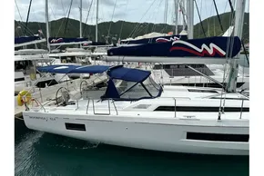 2023 Beneteau Oceanis 51.1 sailboat docked in a marina, featuring sleek design and blue canopy.