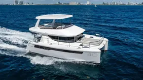 2025 Leopard 40 Powercat cruising on blue ocean near city skyline.