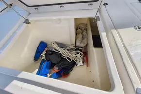 Open storage compartment on 2021 Leopard 50 boat with ropes and diving gear.