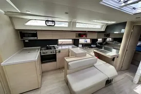 Modern interior of 2023 Beneteau Oceanis 51.1 yacht, featuring a sleek kitchen and seating area.