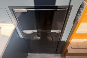 Compact black refrigerator in a modern kitchen, Piper 12c model, 2024.
