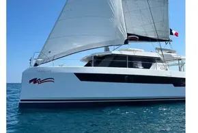 Sailing catamaran Leopard 42, 2022 model, gliding on clear blue ocean waters.