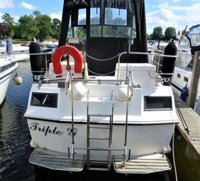 Aquafibre Bounty Boats 10/70, 1995 model, docked with lifebuoy and ladder, sunny day.