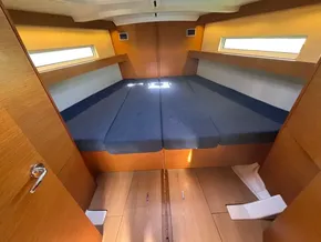 Interior cabin of 2019 Jeanneau Sun Odyssey 440 with wooden finish and blue cushions.