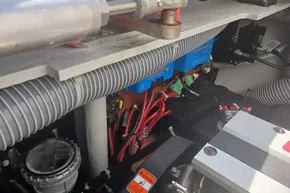 Engine compartment of a 2024 Lagoon 42 catamaran, showcasing wiring and components.