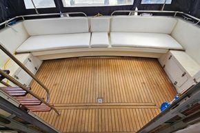 Interior of 1989 Princess 35 Flybridge yacht with wooden flooring and white seating.