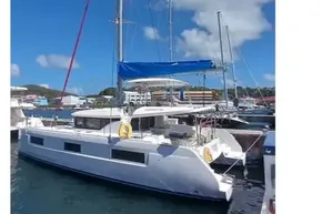 2020 Lagoon 46 catamaran docked at marina under clear blue sky.