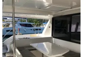 Interior of 2020 Leopard 40 catamaran with seating and table, docked at marina.