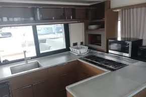 Modern kitchen interior of 2020 Lagoon 46 yacht with stove, sink, and microwave.