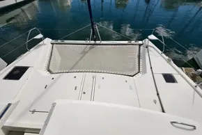 Leopard 50 catamaran deck with netting, reflecting on calm marina waters, 2020 model.