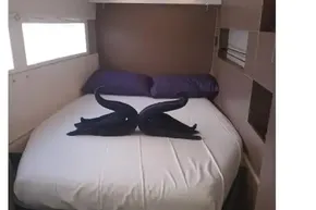 Luxurious cabin interior of 2022 Leopard 45 yacht with elegant bed and towel swans.