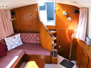 Interior of 1995 Aquafibre Bounty Boats 10/70 with wooden paneling and cozy seating area.