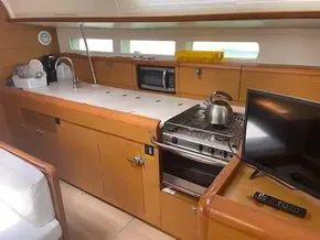2017 Jeanneau Sun Odyssey 519 yacht kitchen with stove, sink, microwave, and TV.