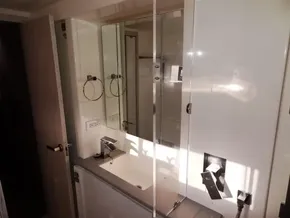 Modern bathroom in 2017 Leopard 43 Powercat with sink, mirror, and storage cabinets.