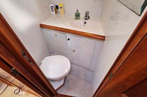 Compact bathroom in a 2005 Stevens 1200 Vlet boat, featuring a sink and toilet.
