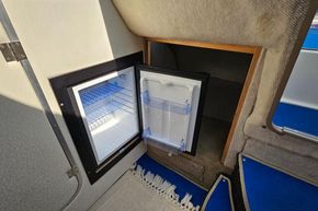 1998 Maxum 2400 SCR cabin interior with open mini fridge.