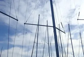 Sailboat masts against a cloudy sky, Jeanneau Sun Odyssey 440, 2019 model.